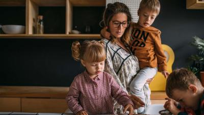 Adult female with three young children in home scene