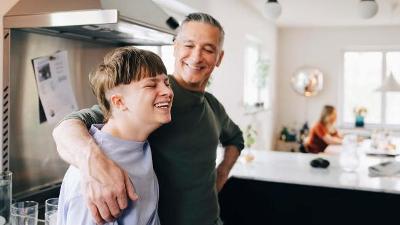 Male with a boy teenager in kitchen and smiling at him